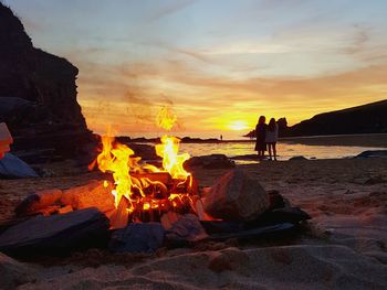 People at beach during sunset