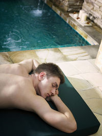 Man relaxing on chair at poolside