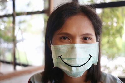 Close-up portrait of woman wearing mask standing indoors