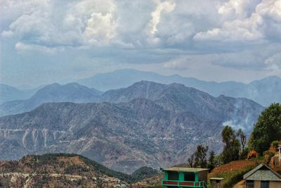 Scenic view of mountains and buildings against sky