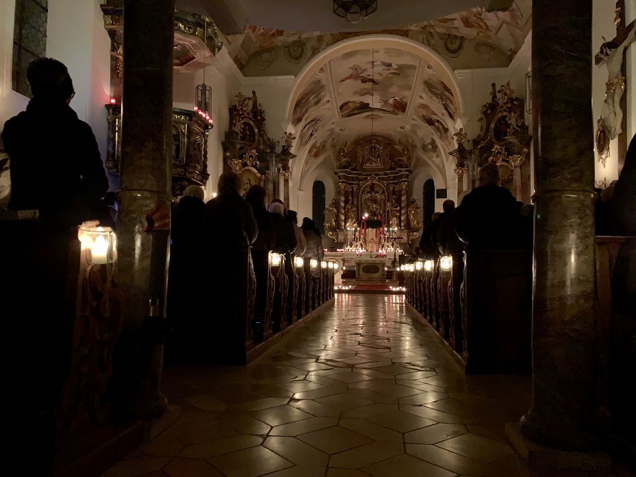 REAR VIEW OF PEOPLE WALKING IN ILLUMINATED TEMPLE