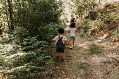 Full length of children walking in forest