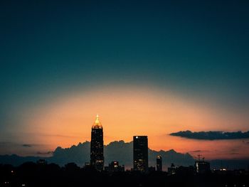 Silhouette buildings against sky during sunset