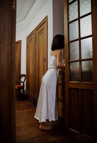 Woman standing by door at home