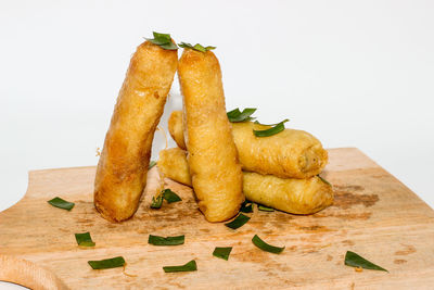 Close-up of bread on cutting board against white background