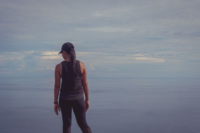 Full length of woman standing on beach against sky