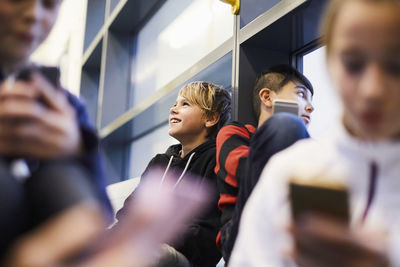 School boys and girl relaxing in corridor