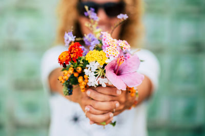 Midsection of woman holding flower bouquet