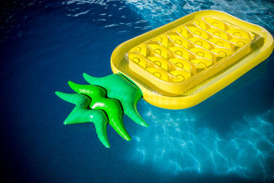Pineapple shaped inflatable raft floating on swimming pool