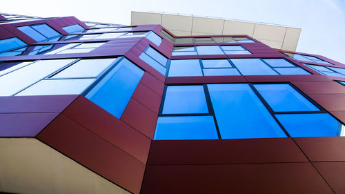 Low angle view of modern building against blue sky