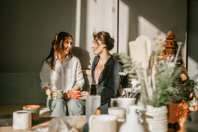 Two women drinking tea in the sunshine in cozy environment