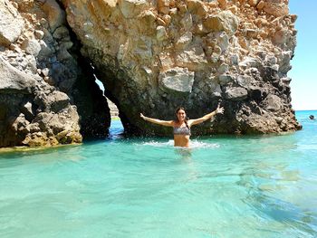 Woman standing on rock in water