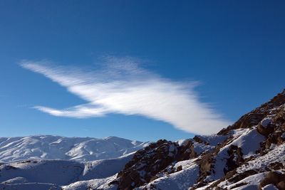 Scenic view of snowcapped mountains against blue sky