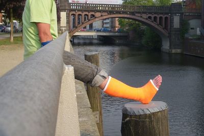 Low section of man on bridge over river