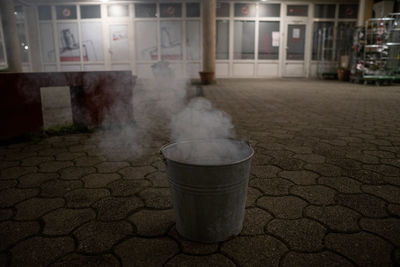 Street light on footpath against building in city