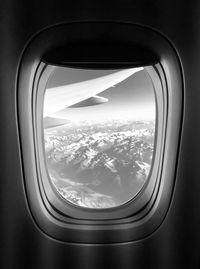 Aerial view of clouds and mountains seen through airplane window