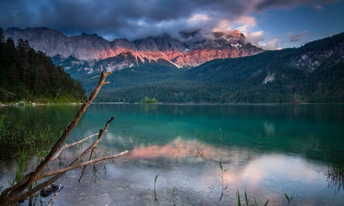 Scenic view of lake by mountains against sky