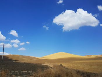 Scenic view of landscape against blue sky