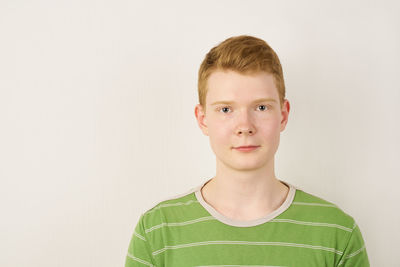 Portrait of boy standing against white background