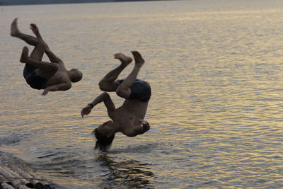 People playing in sea against sky