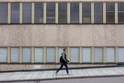 Full length of a man walking on footpath