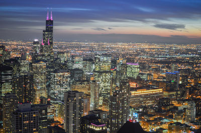 Illuminated cityscape against sky during night