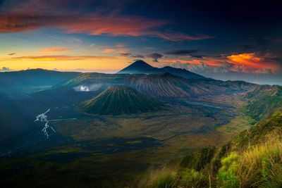 Aerial view of landscape against cloudy sky during sunset