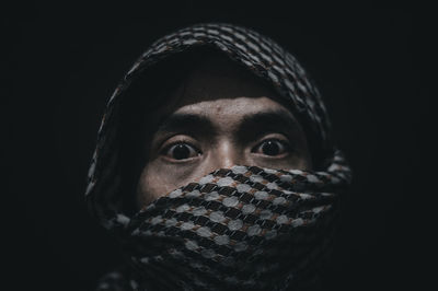 Close-up portrait of mid adult man against black background