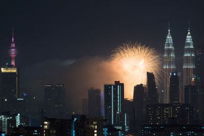 Firework display over city lit up at night