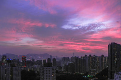 View of cityscape against dramatic sky during sunset