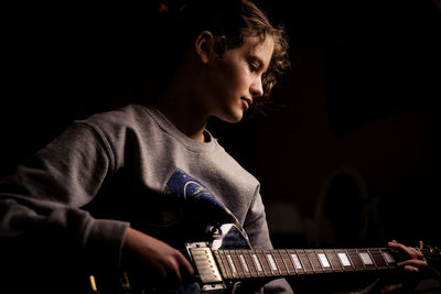 Portrait of young woman playing guitar