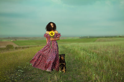 Woman standing on field against sky