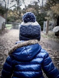 Rear view of boy outdoors during winter
