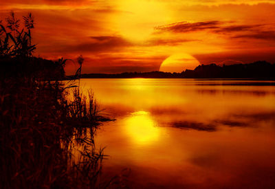 Scenic view of lake against romantic sky at sunset