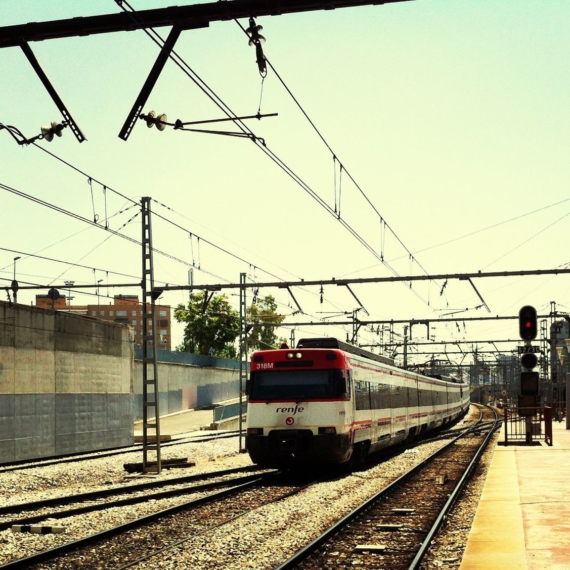 railroad track, transportation, rail transportation, railroad station platform, public transportation, railroad station, power line, electricity pylon, mode of transport, cable, train - vehicle, travel, clear sky, railway track, built structure, connection, passenger train, power supply, sky