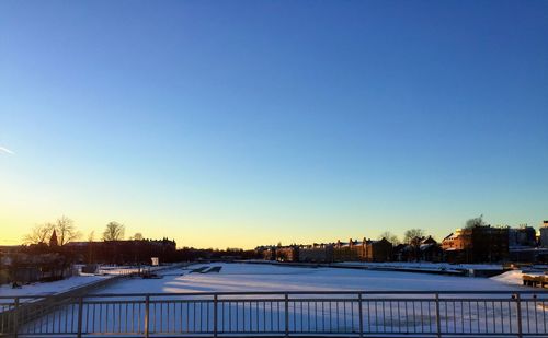 Snow covered landscape against clear sky during winter