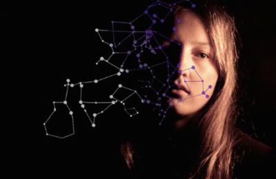 Close-up portrait of young woman against black background