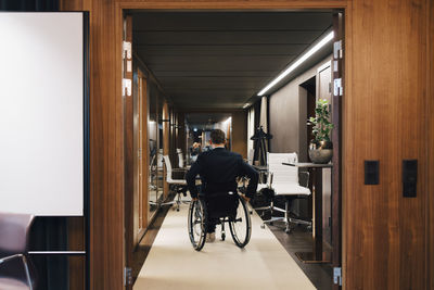 Rear view of disabled businessman on wheelchair in office