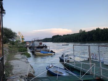 Sailboats moored on river against sky