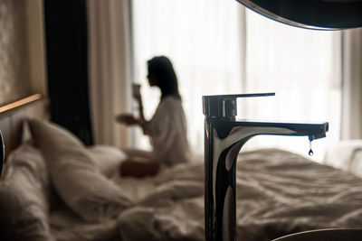 Side view of woman relaxing on bed at home