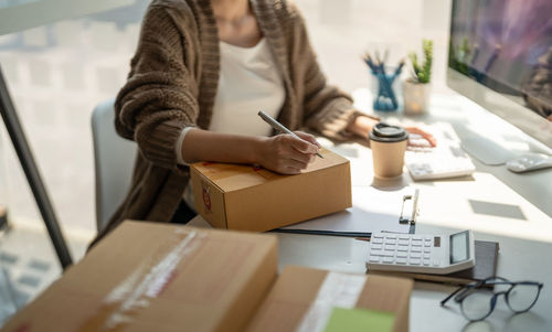Midsection of businessman working at desk in office