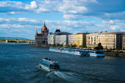 Boats in river with buildings in background