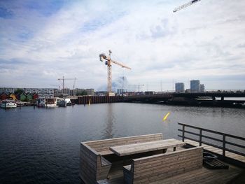 Pier by river against sky in city