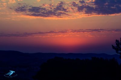 Scenic view of silhouette mountains against sky at sunset