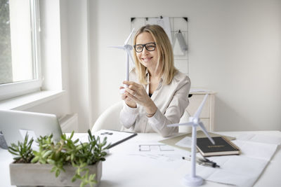 Woman using phone while sitting on table