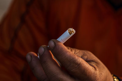 Close-up of hand holding cigarette