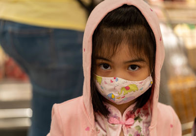 Close-up portrait of cute girl wearing mask