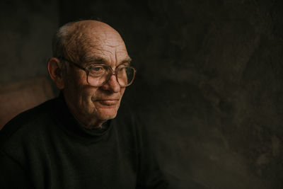 Portrait of serious man standing against black background