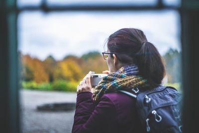 Rear view of woman photographing outdoors