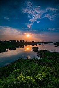 Scenic view of lake against sky at sunset